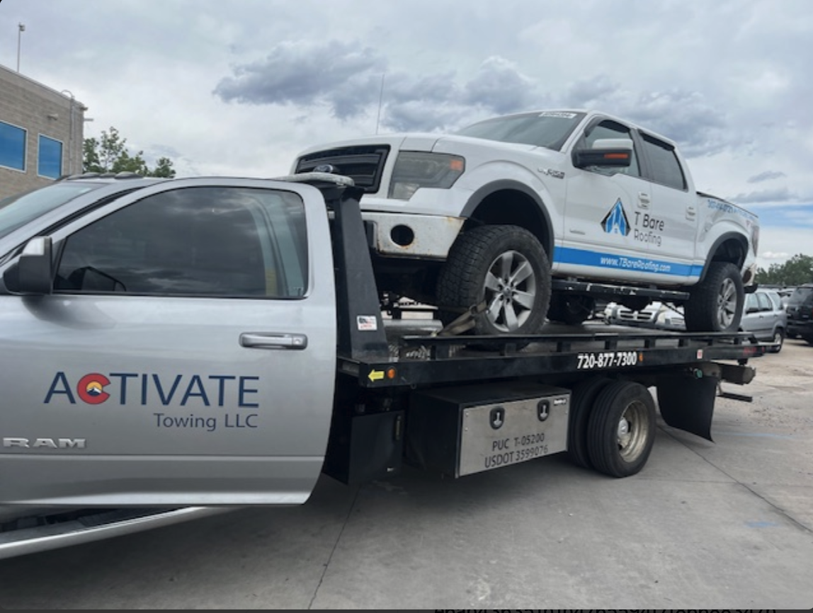 Activate Towing Ram 5500 flatbed hauling a Ford F-150 work truck in Parker, Colorado